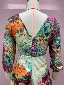 Back view of a long sleeve landscape print dress with colorful abstract pattern on mannequin