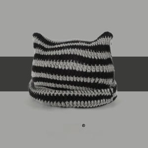 Detail of hand-knitted texture and cat ears on a black and grey striped beanie