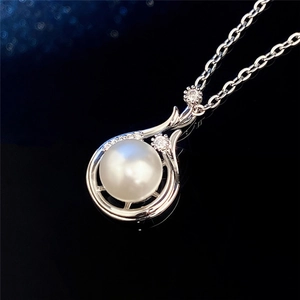 Macro detail of a baroque faux pearl pendant with cubic zirconia on a silver chain