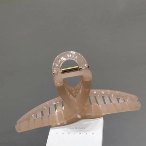 Detail view of large nude pink jelly hair claw clip with golden metal spring