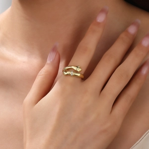 Detail of 18k gold plated ball open ring featuring a unique hugging hands design with zircon