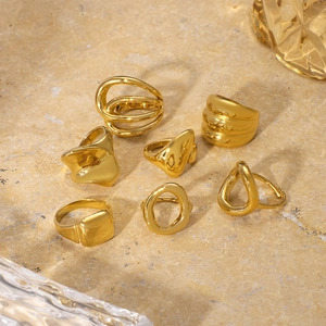Dettaglio di anelli geometrici in acciaio inossidabile placcato oro 18K su pietra