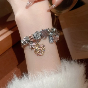 Detailed shot of a silver heart charm bracelet with pink enamel and sparkling crystals