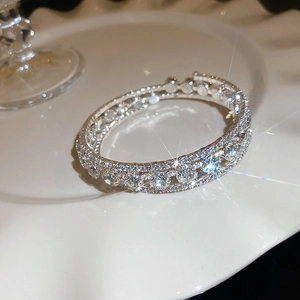 Macro shot of a silver layered floral bracelet with sparkling rhinestones on a white plate