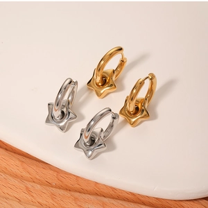 Detailed view of gold and silver stainless steel hoop earrings with star charms