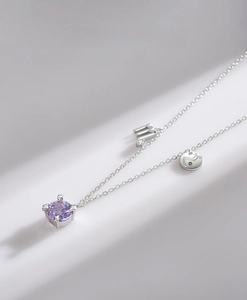 Detail of S925 silver necklace with purple zircon pendant and m-shaped letter charm