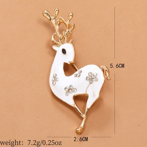 Detail shot of a white enamel deer brooch with gold antlers and crystal rhinestones