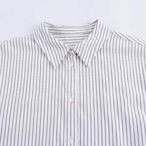 Gros plan sur un col pointu classique d'une chemise à rayures blanches et grises pour femmes