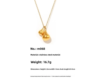 Detailed view of gold plated stainless steel double teardrop pendant on a cross chain