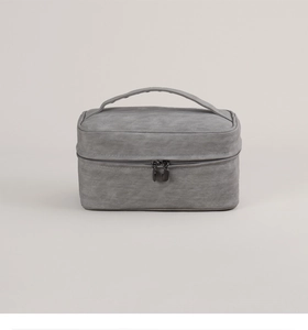Detail of dark grey toiletry bag showing fine textured fabric and top carry handle