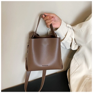 Detail of a dark brown vintage bucket bag with elegant leather texture and handle