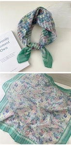 Detailed view of floral cotton linen scarf with green striped borders and small flower patterns
