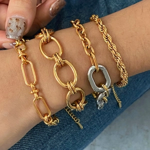 Set of 4 gold and silver stainless steel paperclip and rope chain bracelets on wrist