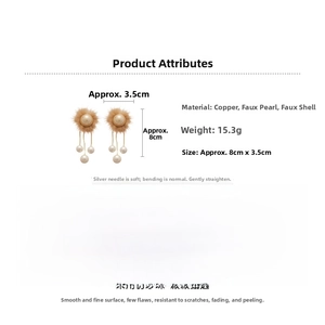 Detail view of brown pom-pom and faux pearl tassel earrings with 8cm length dimensions