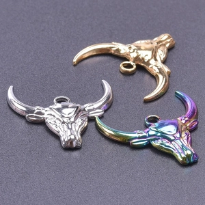 Detailed close-up of bull head pendants in gold, silver, and rainbow stainless steel