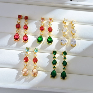 Close-up of luxury teardrop crystal earrings in multiple colors on white leather display