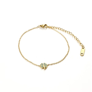 Detail eines Goldkleeblatt-Armbands mit wasserblauen Steinen und S.Steel-Kette
