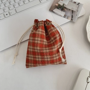Classic red plaid drawstring pouch shown on a desktop with accessories for organization