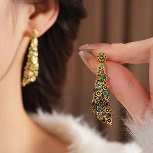 Détail de boucles d'oreilles vintage fleurs avec strass colorés et petites perles