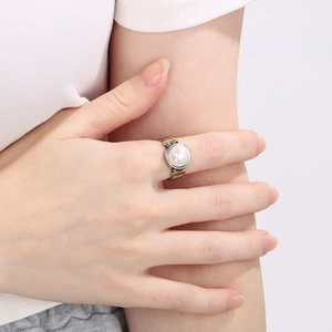 Détail d'une bague bicolore or et argent avec perle centrale sur un anneau en chaîne
