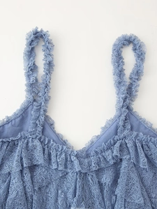Détail du haut en dentelle bleue avec broderies complexes et volants multicouches
