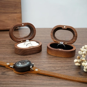 Detail of oval walnut wood jewelry box with flip-top lid showing elegant wood grain
