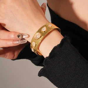 Détail macro de pierres en résine sur un bracelet manchette doré au style vintage