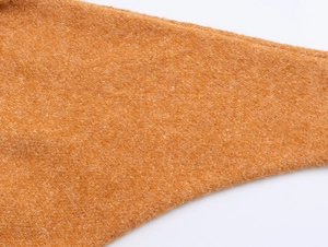 Dettaglio ravvicinato di maglia in lana con texture morbida e cuciture rifinite bene