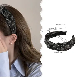 Halloween knot headband with golden spider web pattern shown on model and white background