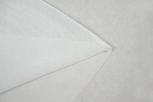 Close-up of breathable white mesh fabric detailing the fine texture and neat hem stitching