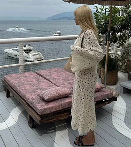 Detailed close-up of white crochet lace maxi dress featuring bohemian bell sleeves and floral patterns