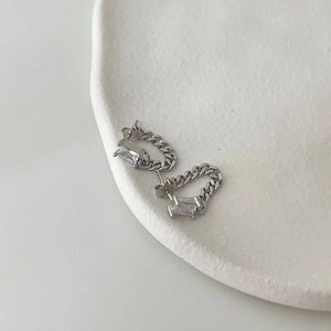 Macro view of silver chain earrings with rectangular cubic zirconia on a white tray