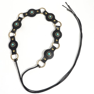 Detail of bohemian black leather belt with turquoise stones and bronze rings