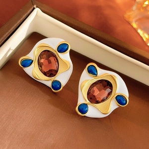 Detail of vintage gold-plated heart pearl earrings with brown and blue gems in a jewelry box