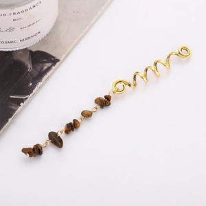 Golden spiral hair accessory with brown natural stone pendant on white background