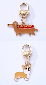 Detail of dachshund and corgi dog enamel pendants with golden heart lobster clasps