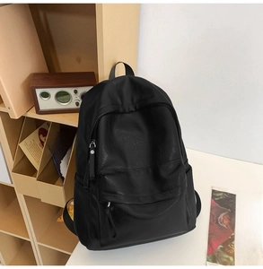 Detail of minimalist large capacity black soft leather backpack in a lifestyle setting