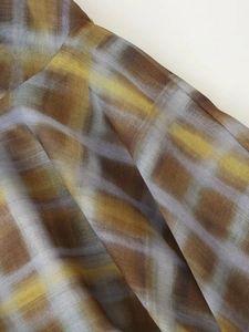 Vue macro montrant la texture du tissu organza à carreaux jaune brun et bleu transparent