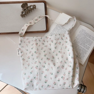Detail of floral cotton shoulder bag with simple wish label and rustic floral print