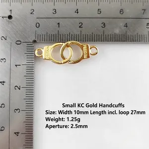 Detail of KC gold alloy handcuffs connector with Freedom engraving on metal ruler