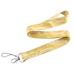 Macro shot of yellow and white marble pattern lanyard with gold glitter and metal lobster clasp