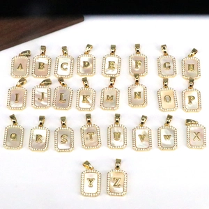 Matrix display of 26 initial shell pendants with gold frames and zircon borders