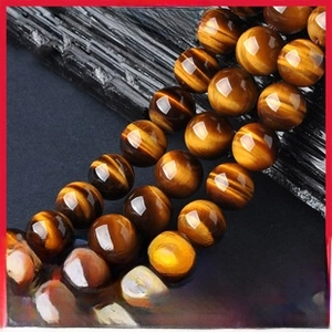 Macro shot of polished yellow wood grain tiger eye beads showing natural chatoyancy