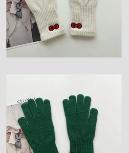 Detailed close-up of thick knitted gloves with ribbed cuffs and bow embroidery