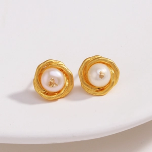 Détail de boucles d'oreilles plaquées or 18k avec texture lave et perle blanche