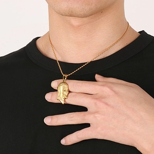 Detailed close-up of 18K gold stainless steel Jesus pendant on a bead chain worn by a model