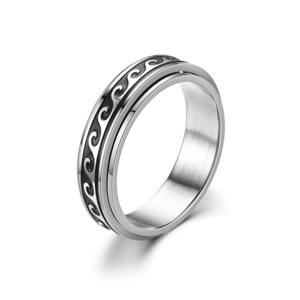 Macro detail of silver stainless steel spinner ring with black engraved wave patterns