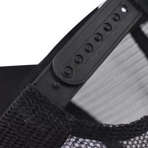 Close-up of black mesh trucker hat with adjustable snapback strap and breathable fabric