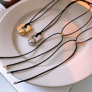 Minimalist irregular U-shaped pendant necklace in gold and silver on black cord