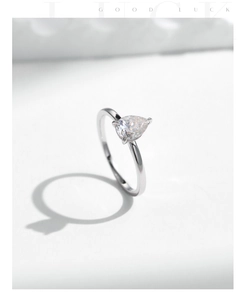 Top view of a silver pear-shaped moissanite ring with elegant sharp shadows on texture